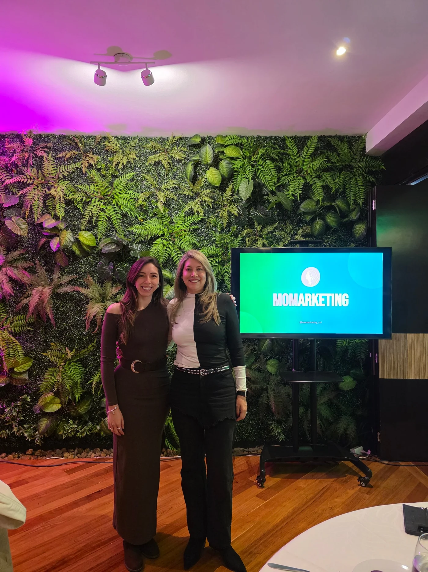 Las fundadoras de MOMarketing junto a la pantalla del evento.